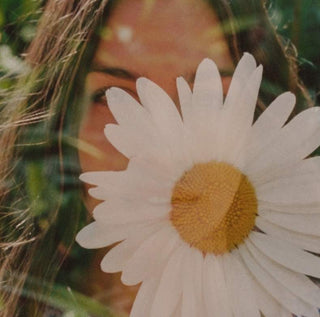 close-up of a woman behind a flower