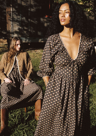 Two women wearing floral dresses outside