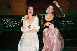 Two women in pretty holiday dresses on a green couch with the title 'Holiday 2026: This collection is a true celebration of the season.'