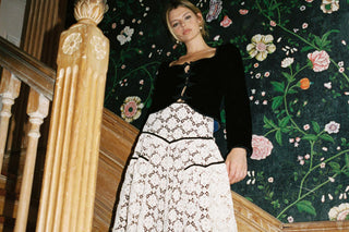 Woman wearing a white skirt and black top standing on a staircase